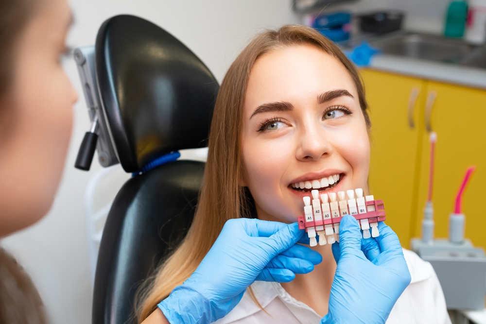 Veneer Shade Selection for Natural Results - Porcelain Veneers Orange County A dentist uses a shade guide to ensure porcelain veneers blend perfectly with the patient’s natural teeth - Porcelain Veneers Orange County