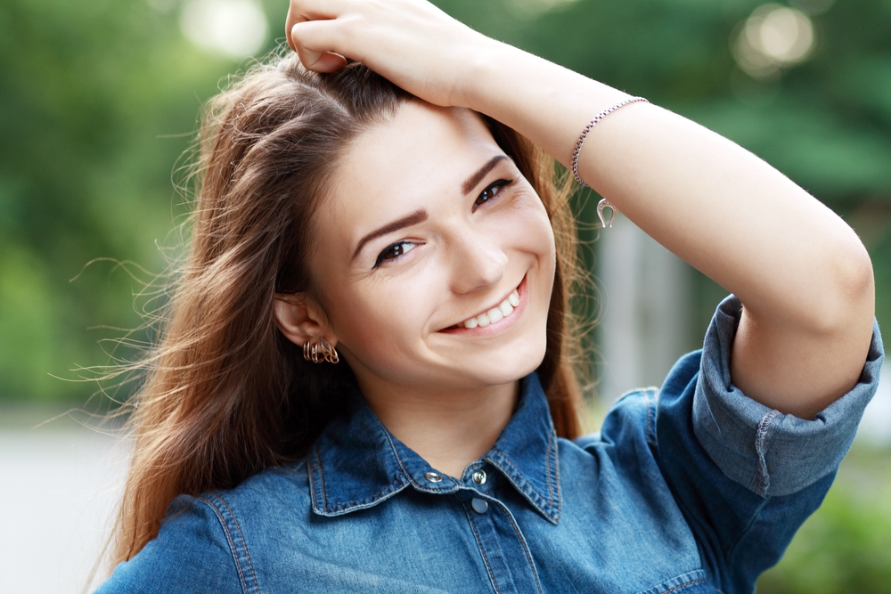 Veneer Color Selection in Office - Porcelain Veneers Orange County A dental professional compares tooth shades to create custom porcelain veneers for a natural cosmetic finish - Porcelain Veneers Orange County