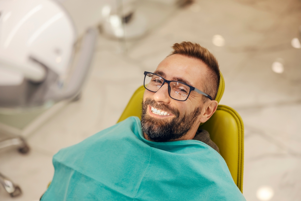 Comfortable Dental Visit Experience – Invisalign Irvine A happy patient resting in a dental chair during a professional and relaxing appointment – Invisalign Irvine