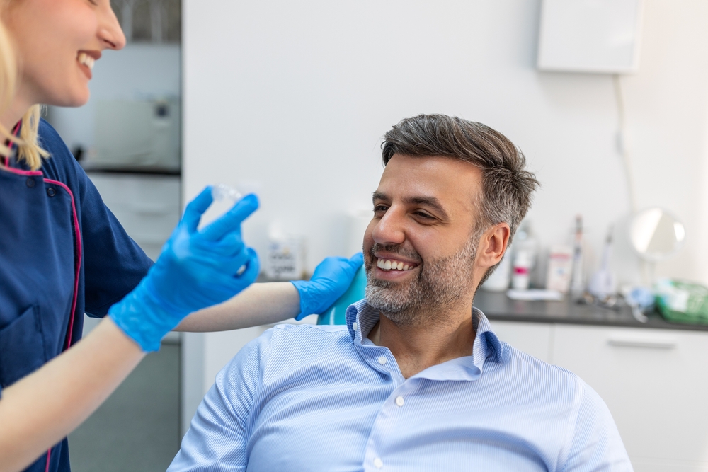 Personalized Invisalign Consultation Visit A dental professional speaking with a patient about clear aligner treatment and smile goals