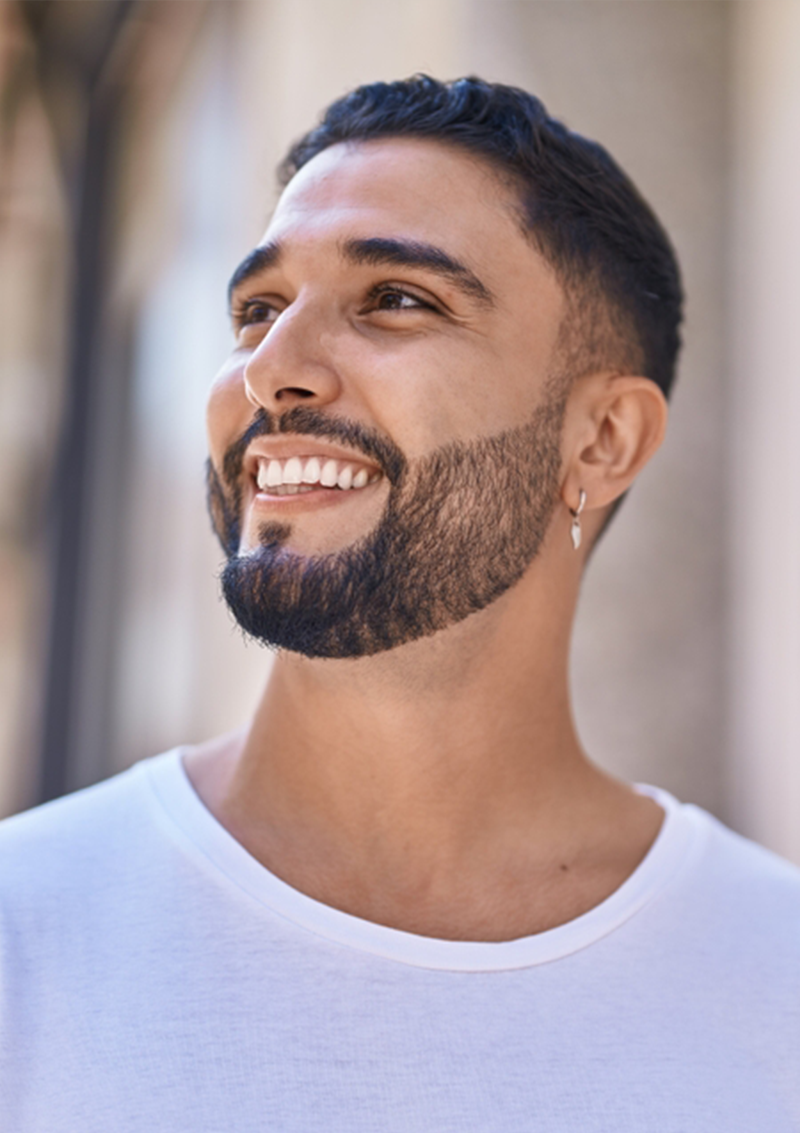 A cheerful man with a radiant smile standing outdoors, showcasing the natural confidence that comes from excellent dental care – Laguna Hills dentist.